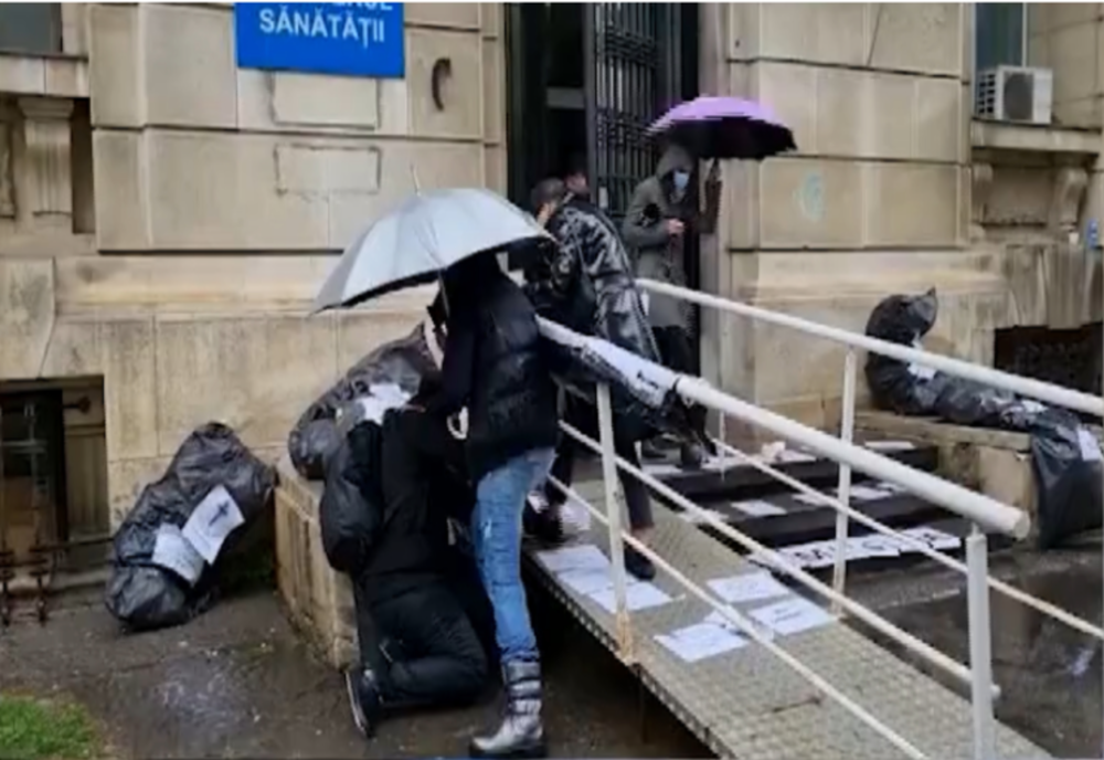 Scene INCREDIBILE în fața Ministerului Sănătății: Bărbat LOVIT CU PICIOARELE de Codruța Cerva și Oana Lovin. Victima, preluată de ambulanță